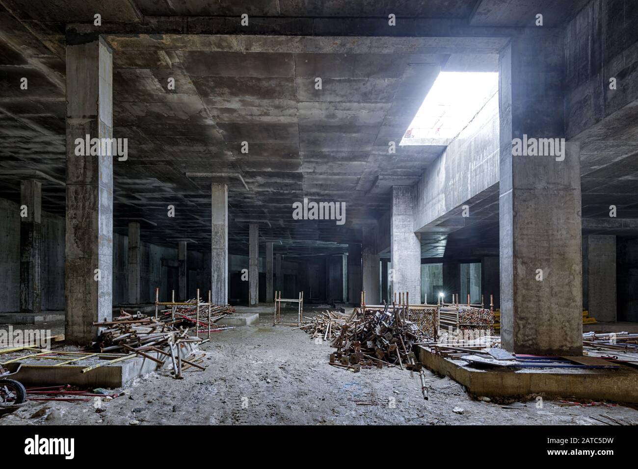 Costruzione in cemento di un seminterrato di un grande edificio. Panorama all'interno del moderno cantiere in buio. Struttura contemporanea in costruzione w Foto Stock