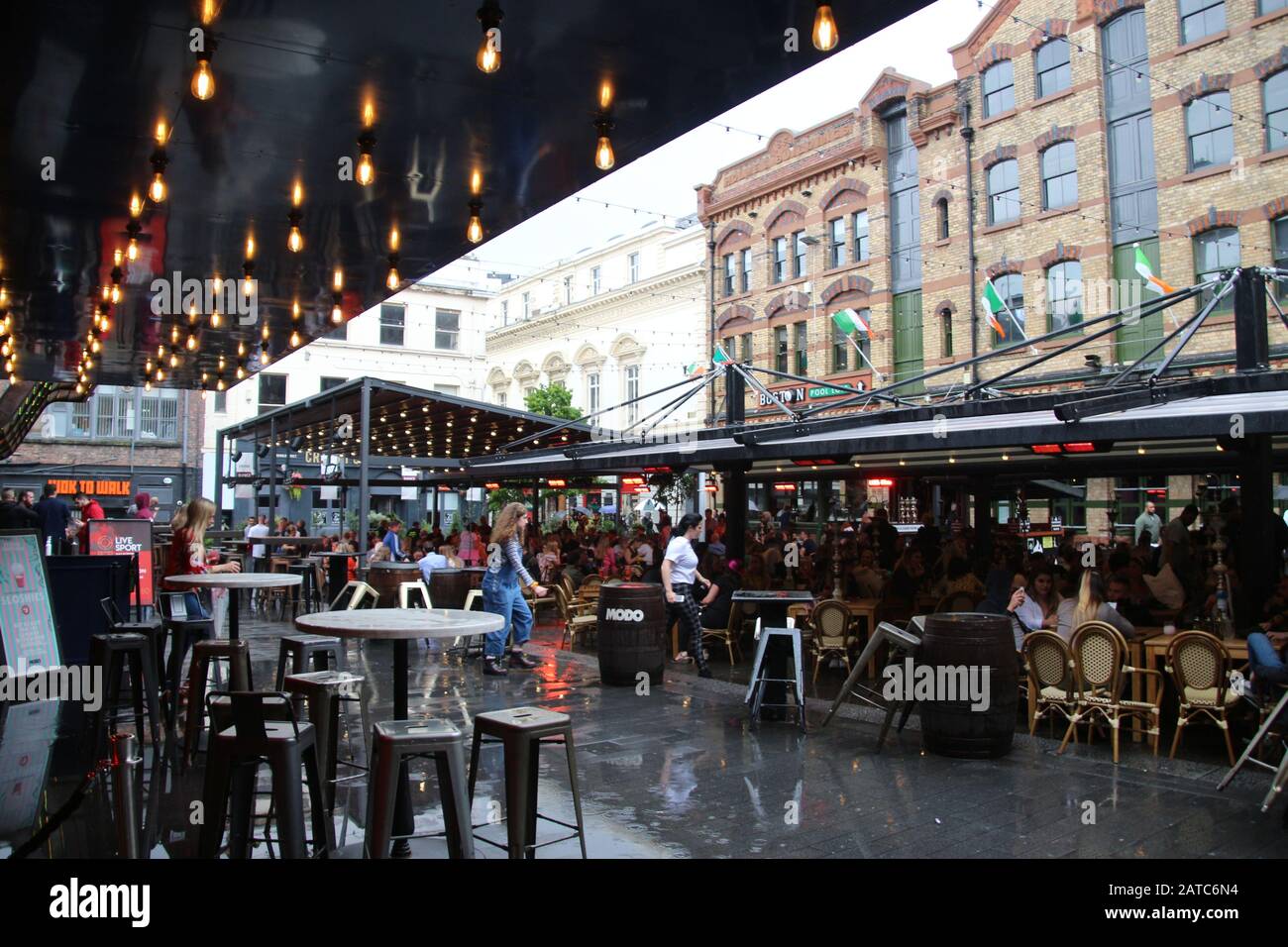 La piazza del concerto a Liverpool, in tempo piovoso, in estate. Molti ospiti si siedono all'esterno. Cavern Quarter, Liverpool. Inghilterra, Europa. Foto Stock