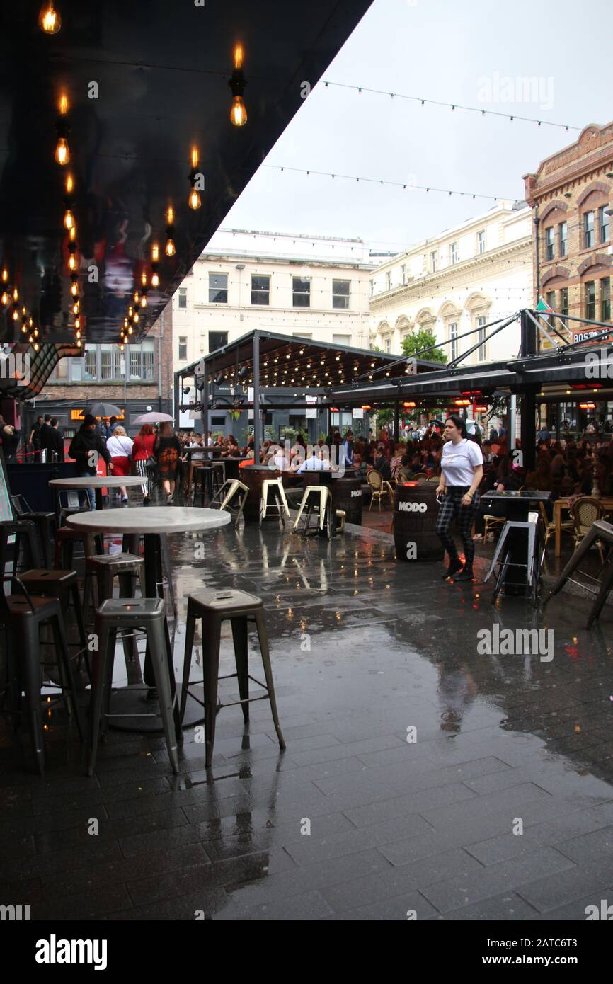 La piazza del concerto a Liverpool, in tempo piovoso, in estate. Molti ospiti si siedono all'esterno. Cavern Quarter, Liverpool. Inghilterra, Europa. Foto Stock