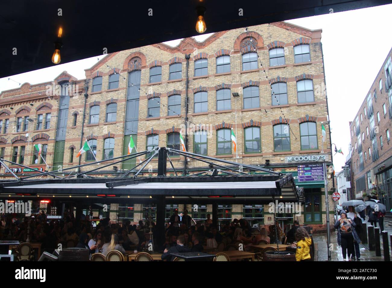La piazza del concerto a Liverpool, in tempo piovoso, in estate. Molti ospiti si siedono all'esterno. Cavern Quarter, Liverpool. Inghilterra, Europa. Foto Stock