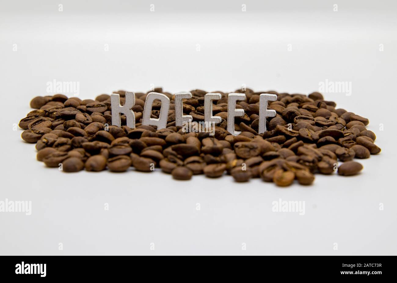 Kaffee scritto in lettere di legno e chicchi di caffè isolato su sfondo bianco Foto Stock