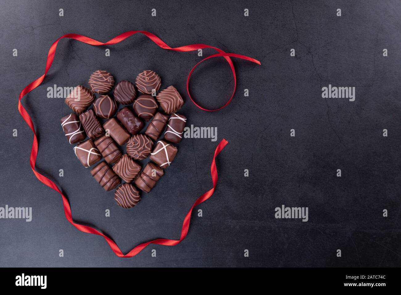 Praline di cioccolato per San Valentino o Mothers Day concept su sfondo nero Foto Stock