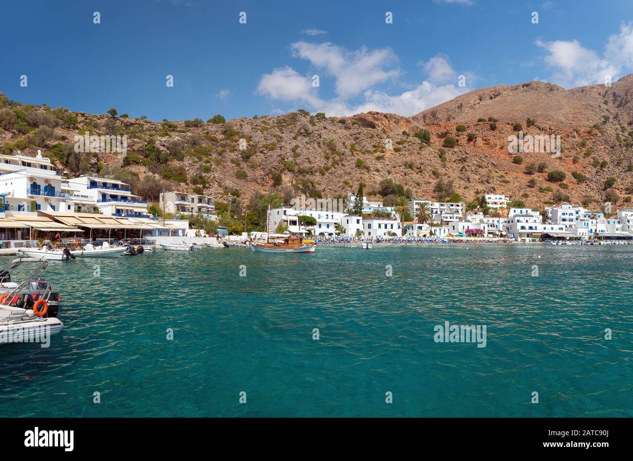 LOUTRO, GRECIA - AGOSTO 2019: Bellissima città con piccolo porto e barche ormeggiate vicino al molo nella parte meridionale dell'isola di Creta Foto Stock