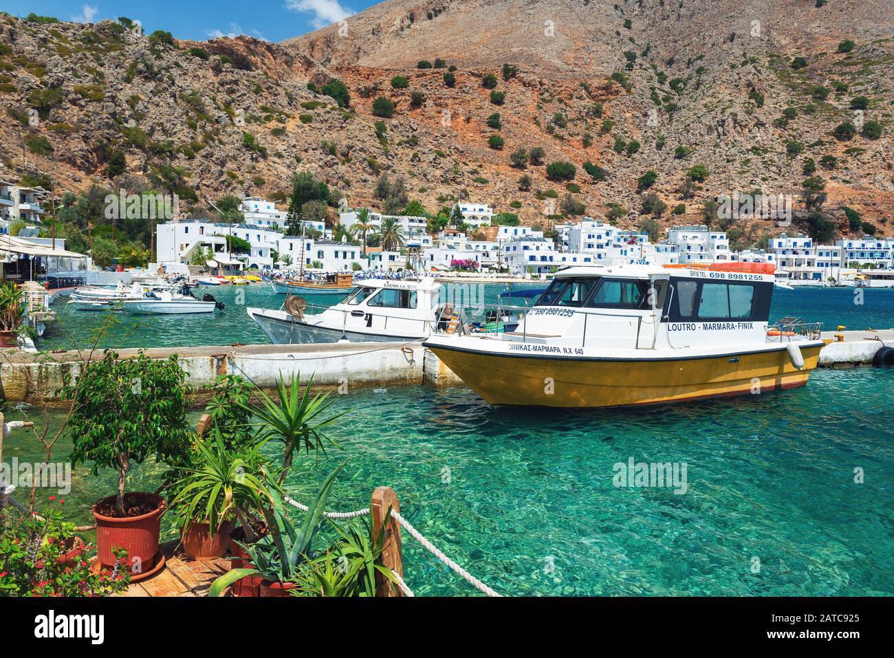 LOUTRO, GRECIA - AGOSTO 2019: Bellissima città con piccolo porto e barche ormeggiate vicino al molo nella parte meridionale dell'isola di Creta Foto Stock