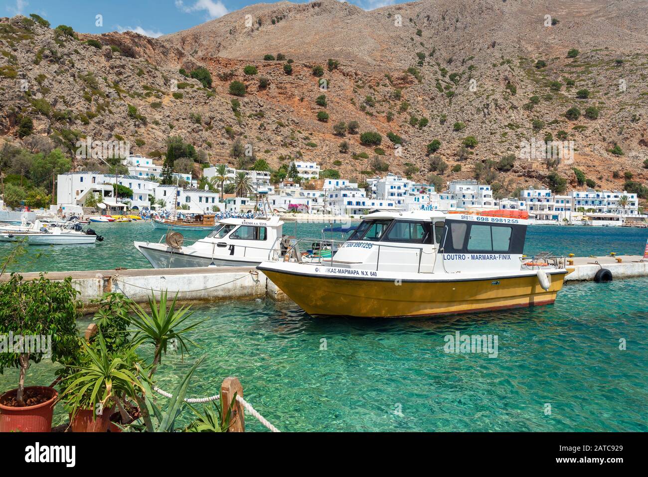 LOUTRO, GRECIA - AGOSTO 2019: Bellissima città con piccolo porto e barche ormeggiate vicino al molo nella parte meridionale dell'isola di Creta Foto Stock