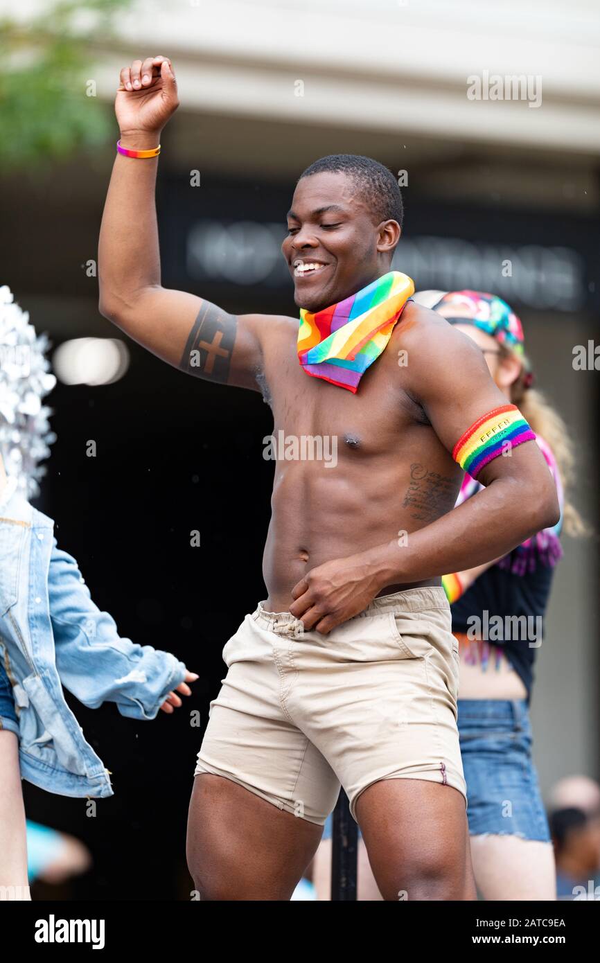 Cincinnati, Ohio, Stati Uniti d'America - 22 giugno 2019: La Cincinnati Pride Parade, Man con la bandiera arcobaleno che balla su un galleggiante durante la parata Foto Stock
