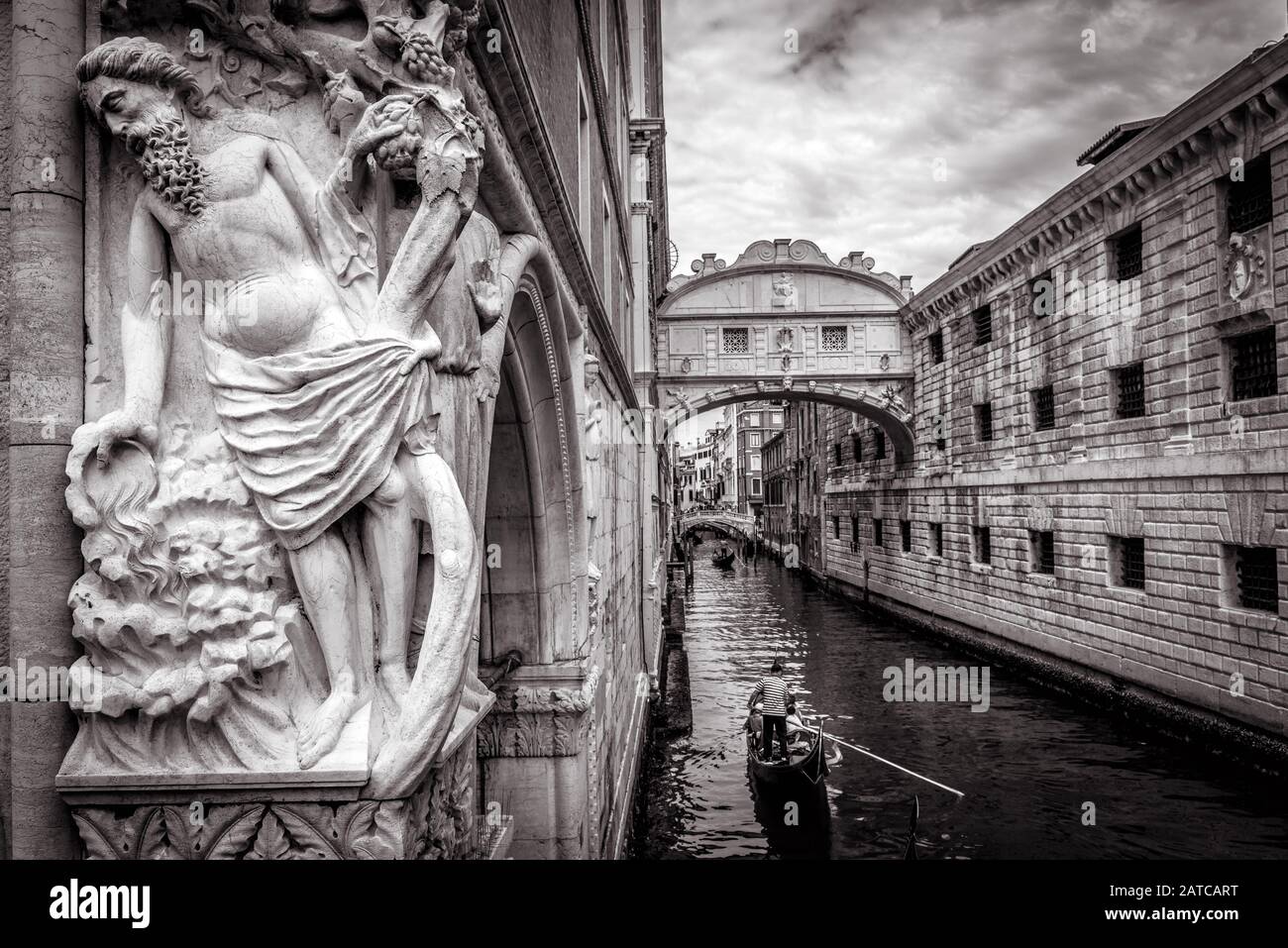 Venezia paesaggio urbano con vecchia scultura in bianco e nero, Italia. Le gondole turistiche navigano sotto il famoso Ponte dei Sospiri. E' un punto di riferimento di Venezia. Romanti Foto Stock