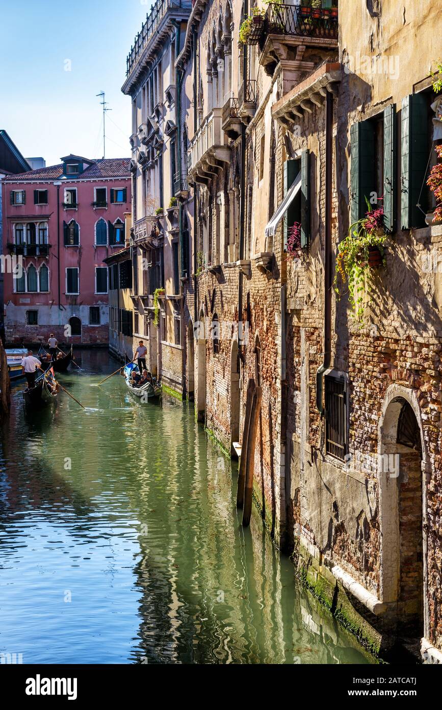 Venezia, Italia - 21 maggio 2017: Le gondole con i turisti galleggiano lungo la vecchia stradina. La gondola è il mezzo di trasporto turistico più attraente di Venezia. Foto Stock