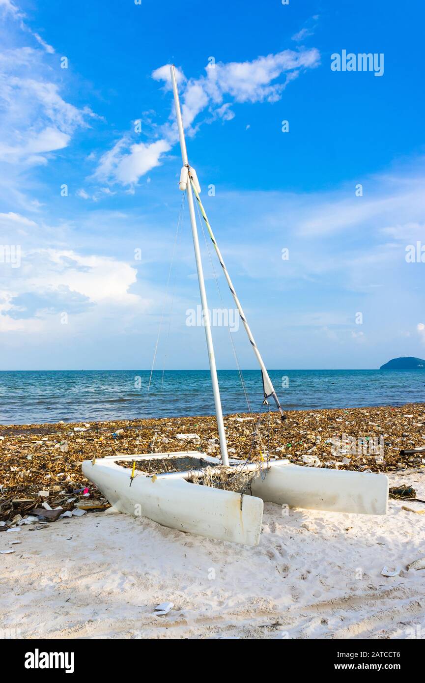 Catamarano è tra i rifiuti. Disastro ambientale. Immondizia discarica sulla spiaggia di bai sao con sabbia bianca sulla costa. Foto Stock