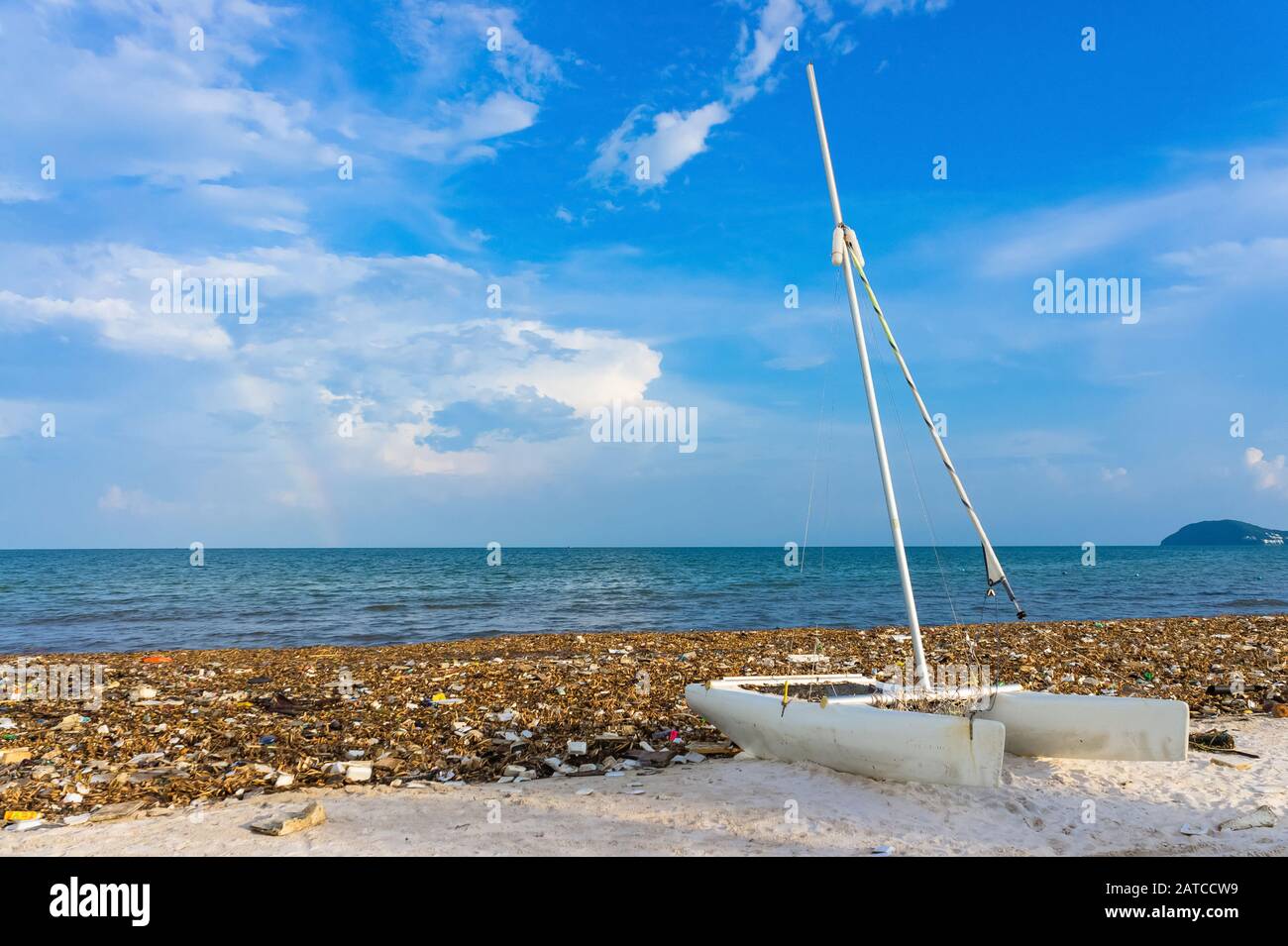 Catamarano è tra i rifiuti. Disastro ambientale. Immondizia discarica sulla spiaggia di bai sao con sabbia bianca sulla costa. Foto Stock