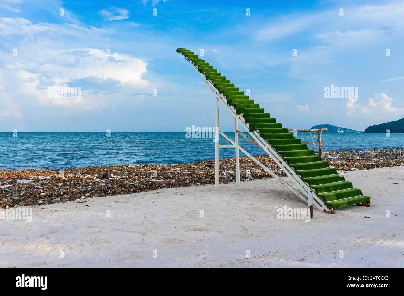 Scala verde al cielo, scenario, fotozona sulla spiaggia, in mezzo al disastro ambientale a Phu Quoc in Vietnam. Immondizia discarica sulla spiaggia di bai sao Foto Stock