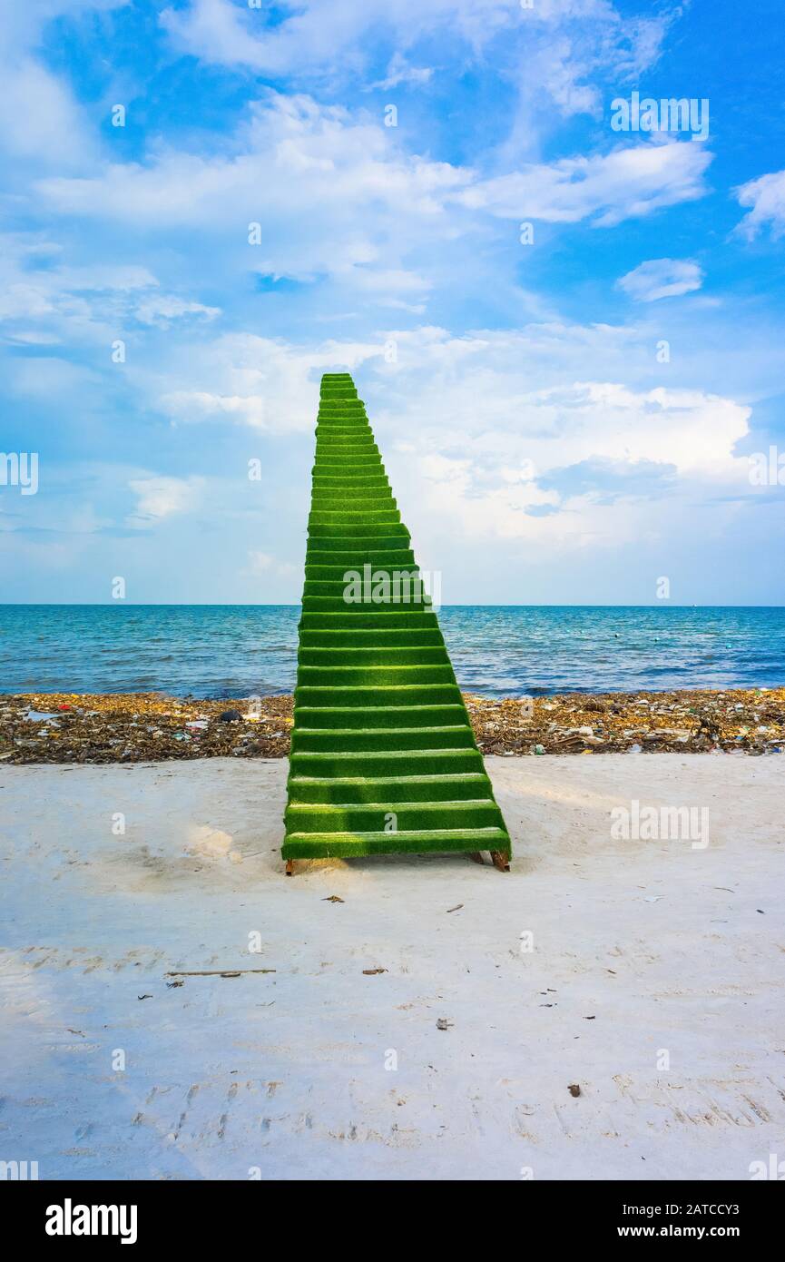 Scala verde al cielo, scenario, fotozona sulla spiaggia, in mezzo al disastro ambientale a Phu Quoc in Vietnam. Immondizia discarica sulla spiaggia di bai sao Foto Stock