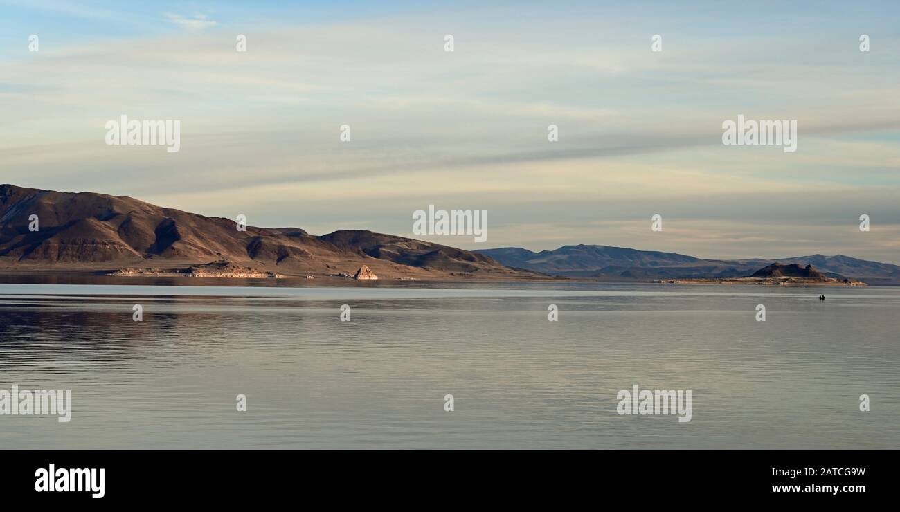 Formazioni rocciose e riflessi del Pyramid Lake, Nevada, in chiaro e tranquillo pomeriggio invernale. Foto Stock