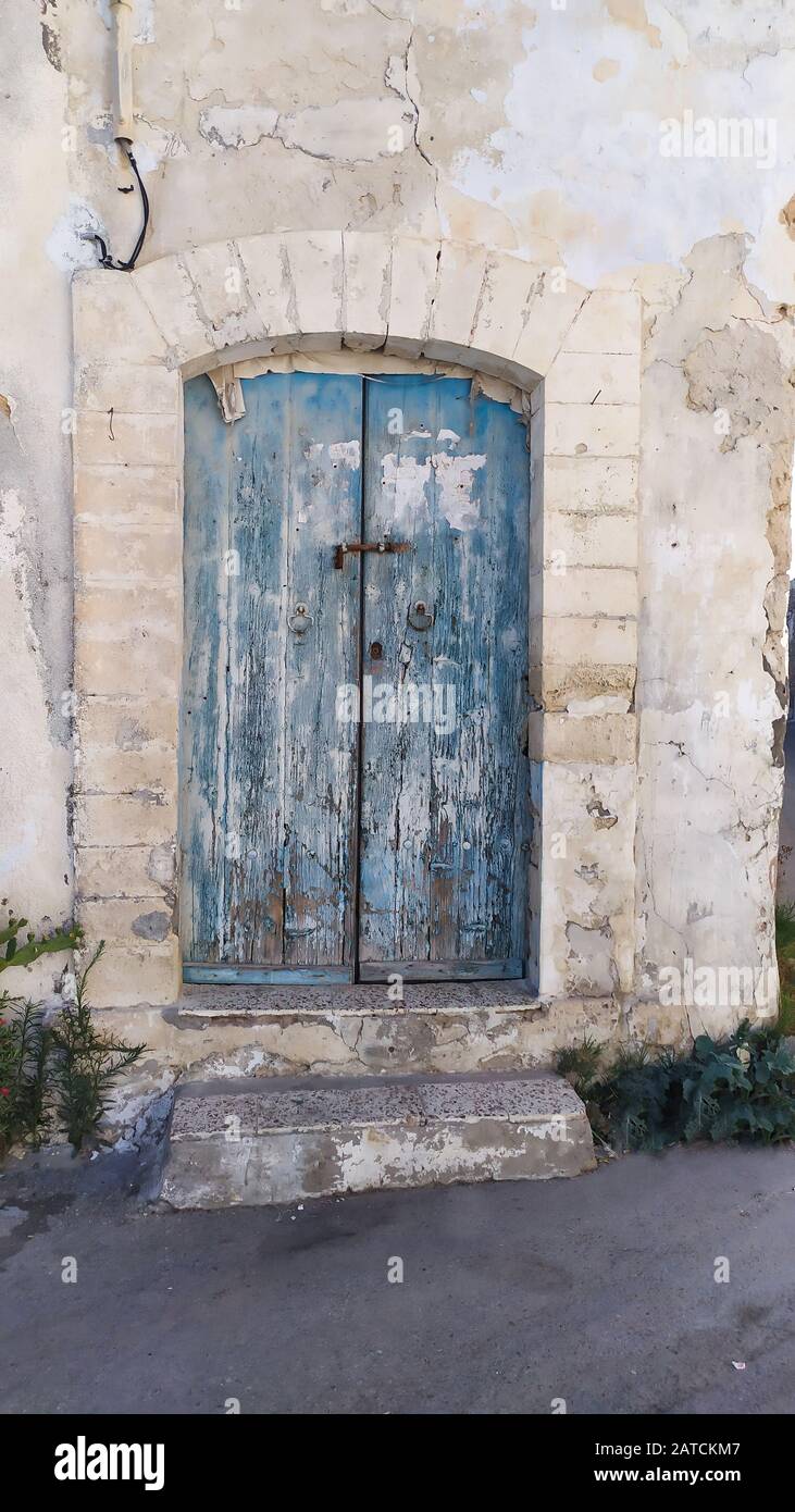 Tradizionale porta dipinta molto vecchia in un quartiere storico o medina, Tunisia. Immagine colorata e testurizzata dell'architettura musulmana. Foto Stock