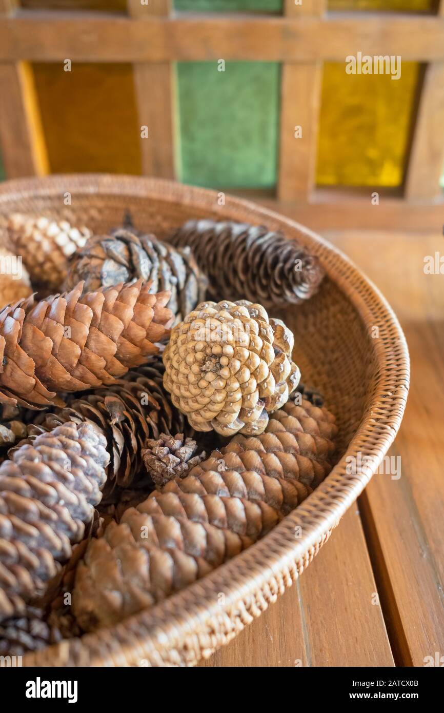 Cesto di rattan con coni di pino vicino Foto Stock