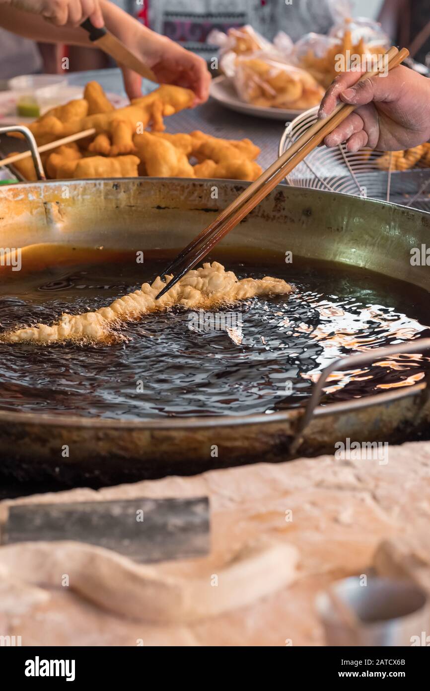 La cucina dello chef fritte bastoncini di pasta - tradizionale thai street food dessert Foto Stock