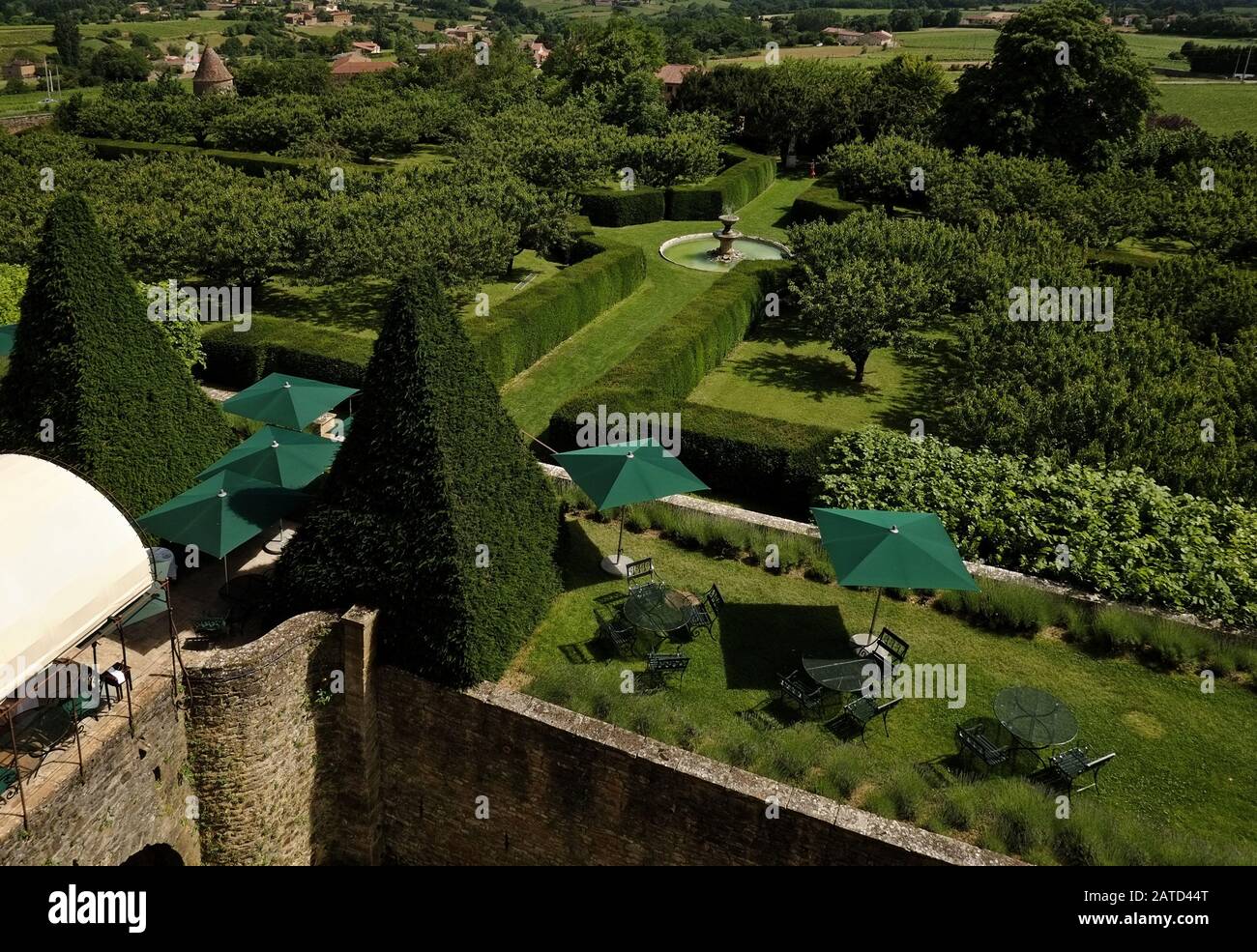 Vista dall'alto del fossato della terrazza da pranzo e della fontana nel giardino formale e frutteto dell'Château de Bagnols, provincia di Beaujolais, Francia. Foto Stock