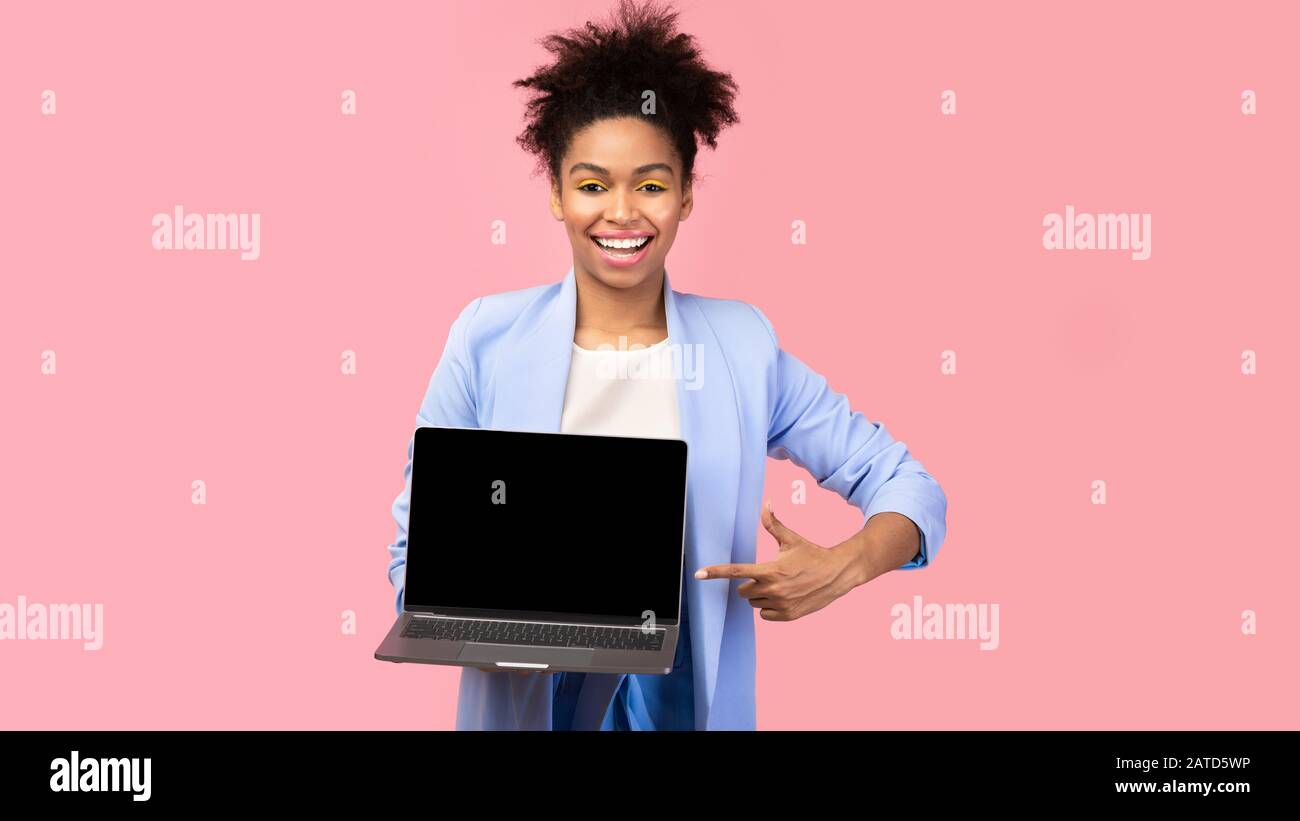 Felice afro ragazza che mostra nero schermo vuoto computer Foto Stock