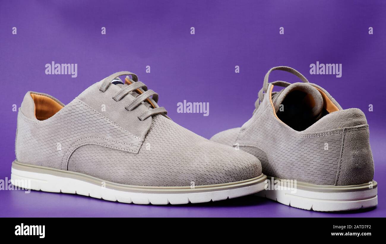 Scarpe uomo casual grigio vista laterale su sfondo viola Foto Stock