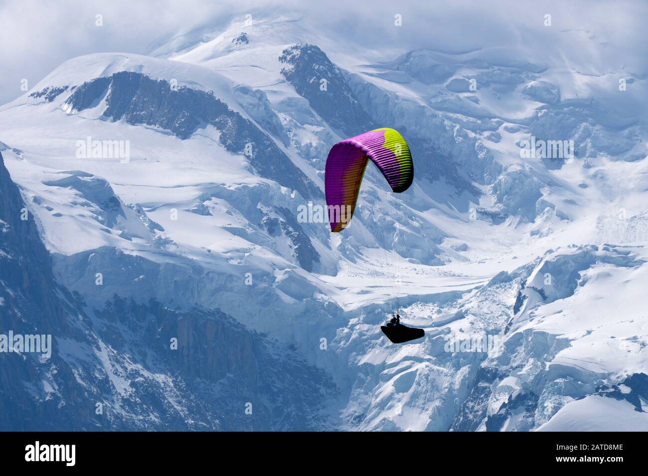 Parapendio in cerca di terme tra le cime innevate del Massiccio del Monte Bianco, Chamonix, Francia Foto Stock