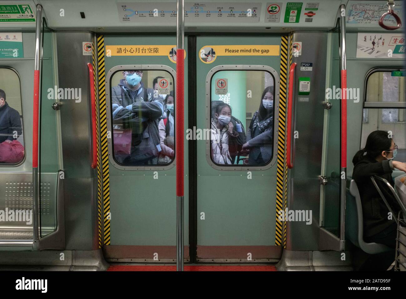 I passeggeri indossano maschere chirurgiche e aspettano di entrare in un treno MTR nella stazione lo Wu al confine con Shenzhen a Hong Kong. L'Organizzazione Mondiale della Sanità ha chiamato un'emergenza sanitaria globale, invertendo la decisione precedente sull'epidemia di coronavirus. Finora ci sono 13 casi confermati di coronavirus a Hong Kong, mentre il totale dei casi confermati è salito a 14.549 e il numero dei decessi è salito a 305. Foto Stock