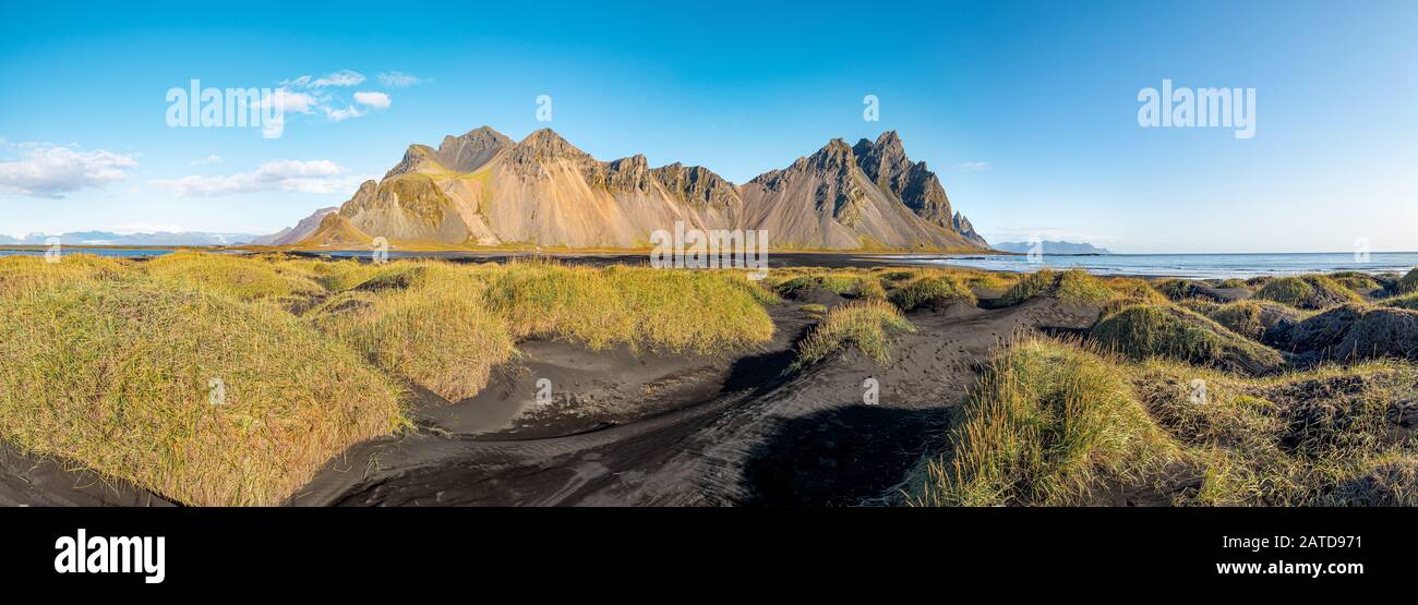 Panorama epico della spiaggia di sabbia nera a Stokksnes in una giornata di sole. Il monte Vestrahorn sullo sfondo. Natura ed ecologia di concetto di fondo. Foto Stock