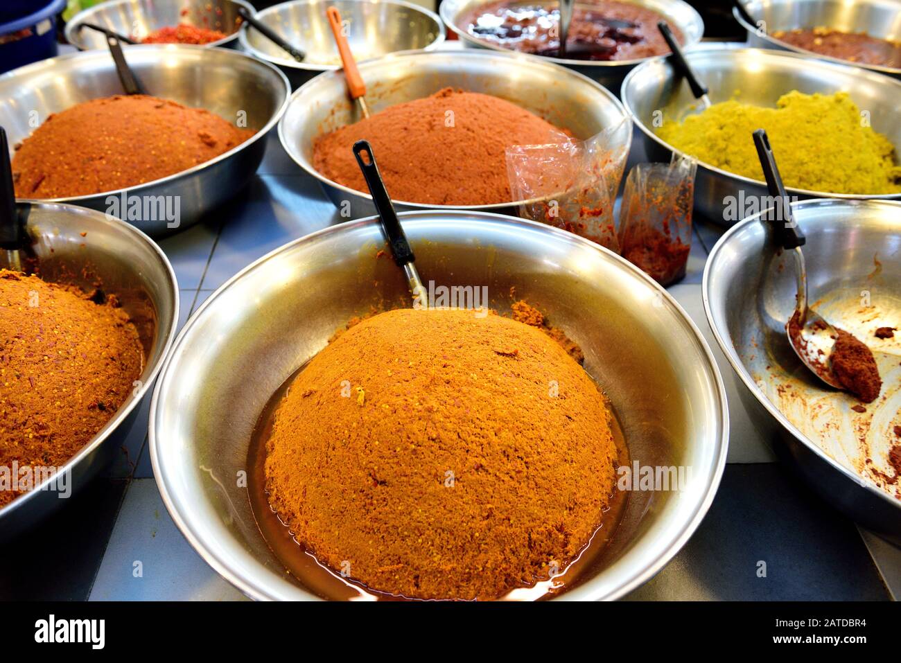 Vista ad alto angolo di diverse grandi ciotole di pasta di peperoncino tailandese, Nam Prik Pao in un mercato di strada a Bangkok, Thailandia Foto Stock