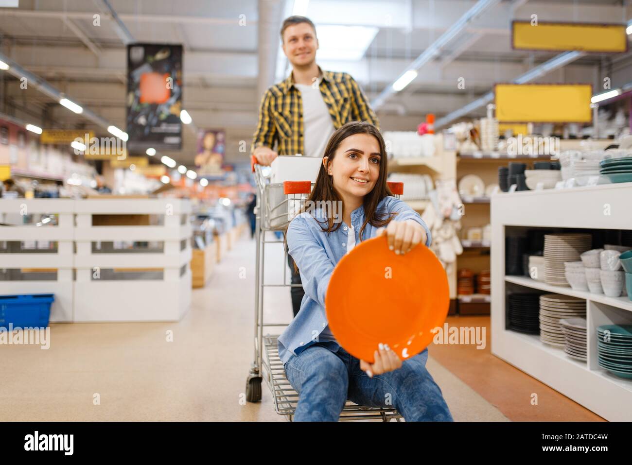 Coppia scherzi con carrello e piatto, negozio di casalinghi Foto Stock