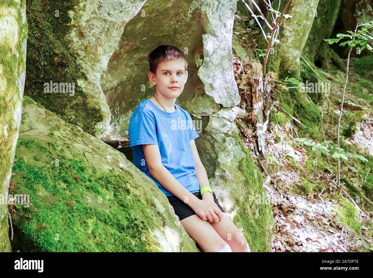 Il ragazzo studia allegramente tutto nelle grotte di montagna Foto Stock
