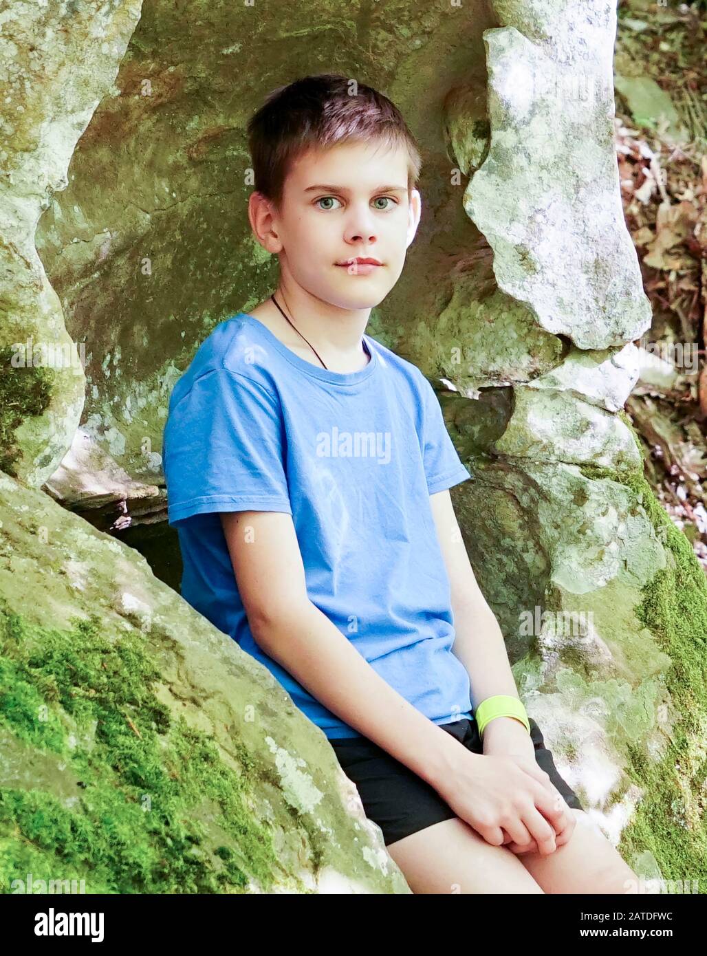 Il ragazzo studia allegramente tutto nelle grotte di montagna Foto Stock