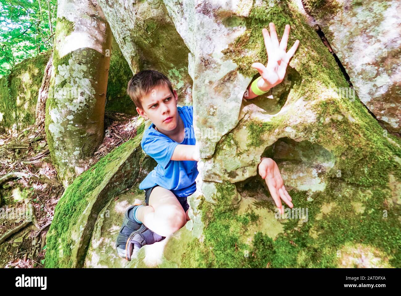 Il ragazzo studia allegramente tutto nelle grotte di montagna Foto Stock