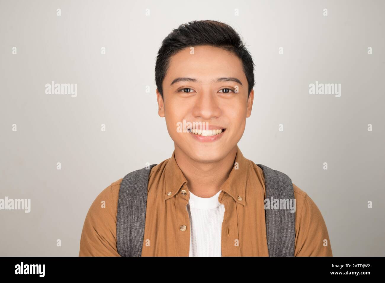 Ritratto di bello studente asiatico zaino porta isolata su sfondo bianco Foto Stock