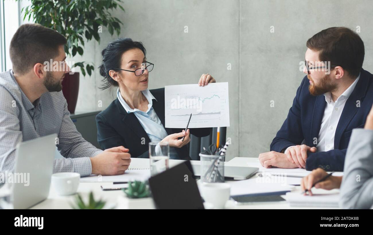 Il project manager tiene un rapporto finanziario, mostrando statistiche in aumento Foto Stock