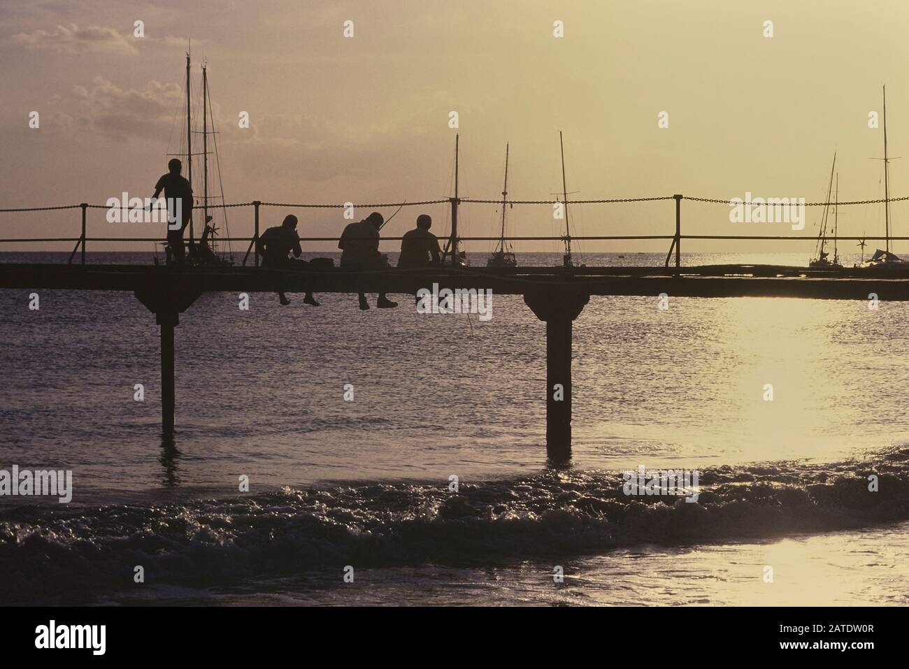 Bajan uomini pesca da un molo di legno. Barbados. Caraibi. Indie Occidentali Foto Stock