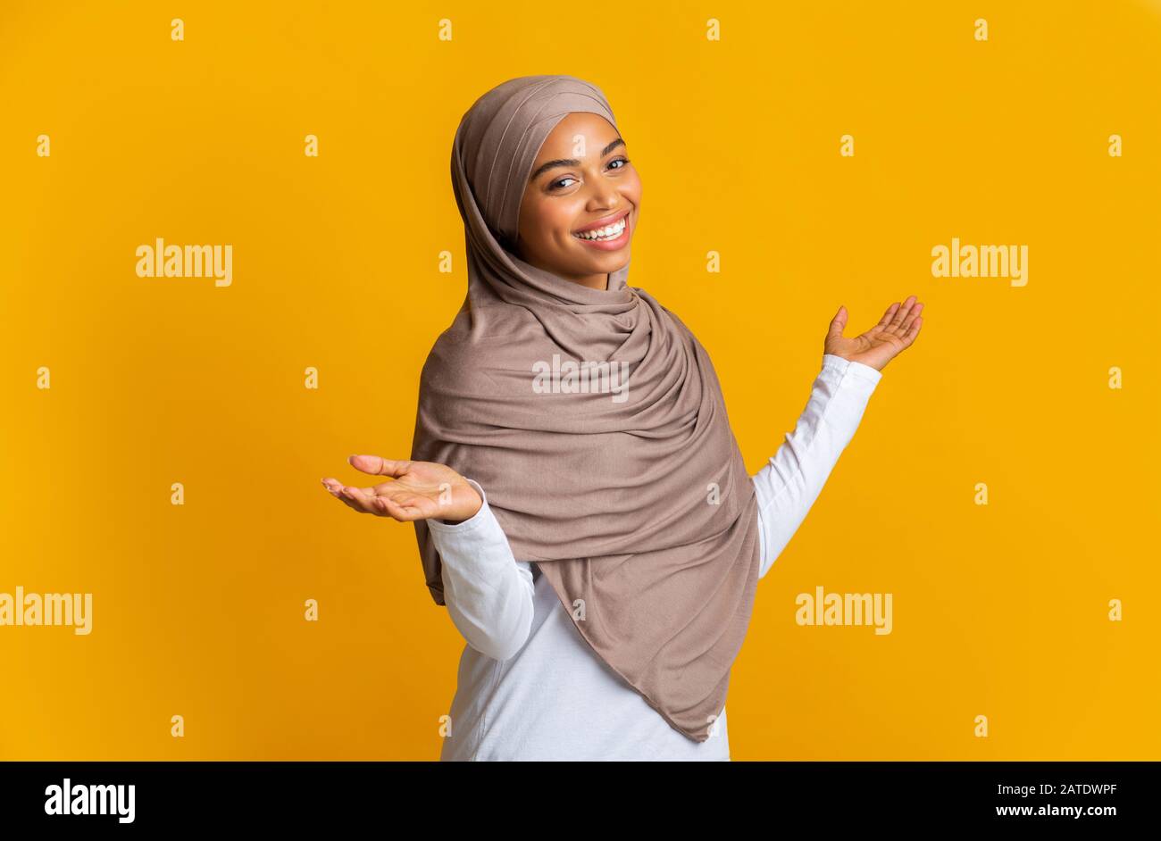 Ritratto di spensierata ragazza islamica afro in velo con braccia spalmate Foto Stock