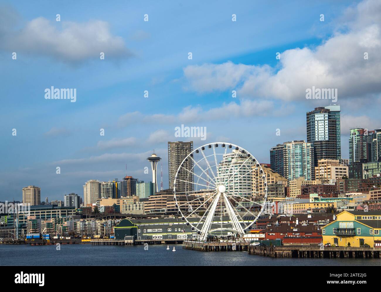 Lungomare e skyline di Seattle, con lo Space Needle che mostra attraverso i raggi della ruota della Grande ruota panoramica in primo piano. Immagine colorata Foto Stock