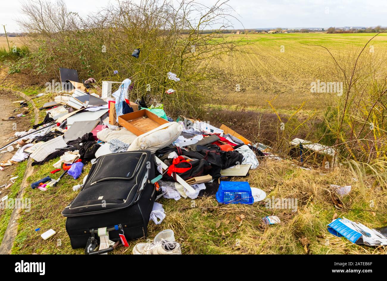 Vola giù per una tranquilla strada di campagna. La quantità estrema di rifiuti domestici scaricati illegalmente in campagna aperta provoca uno spaventoso blot sulle terre Foto Stock