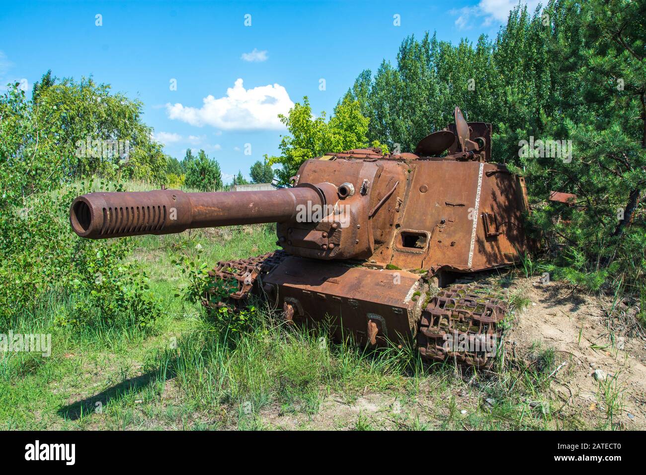Auto abbandonata e arrugginita in un campo in una giornata di sole con cielo blu e nuvole nella centrale nucleare di Chernobyl zona di alienazione Foto Stock