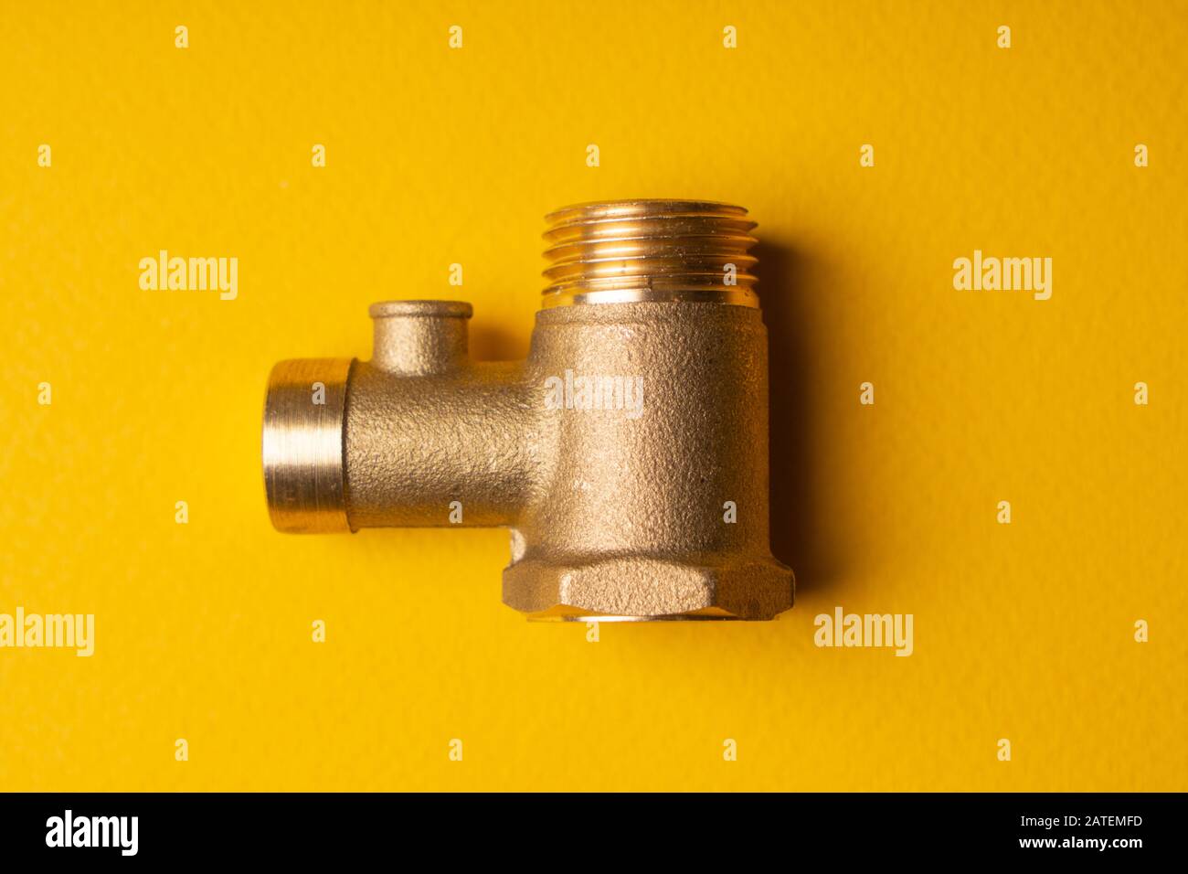 Valvola Di Ritegno In Bronzo. Valvola di non ritorno per l'acqua nel sistema di riscaldamento elettrico dell'acqua. Su sfondo giallo Foto Stock