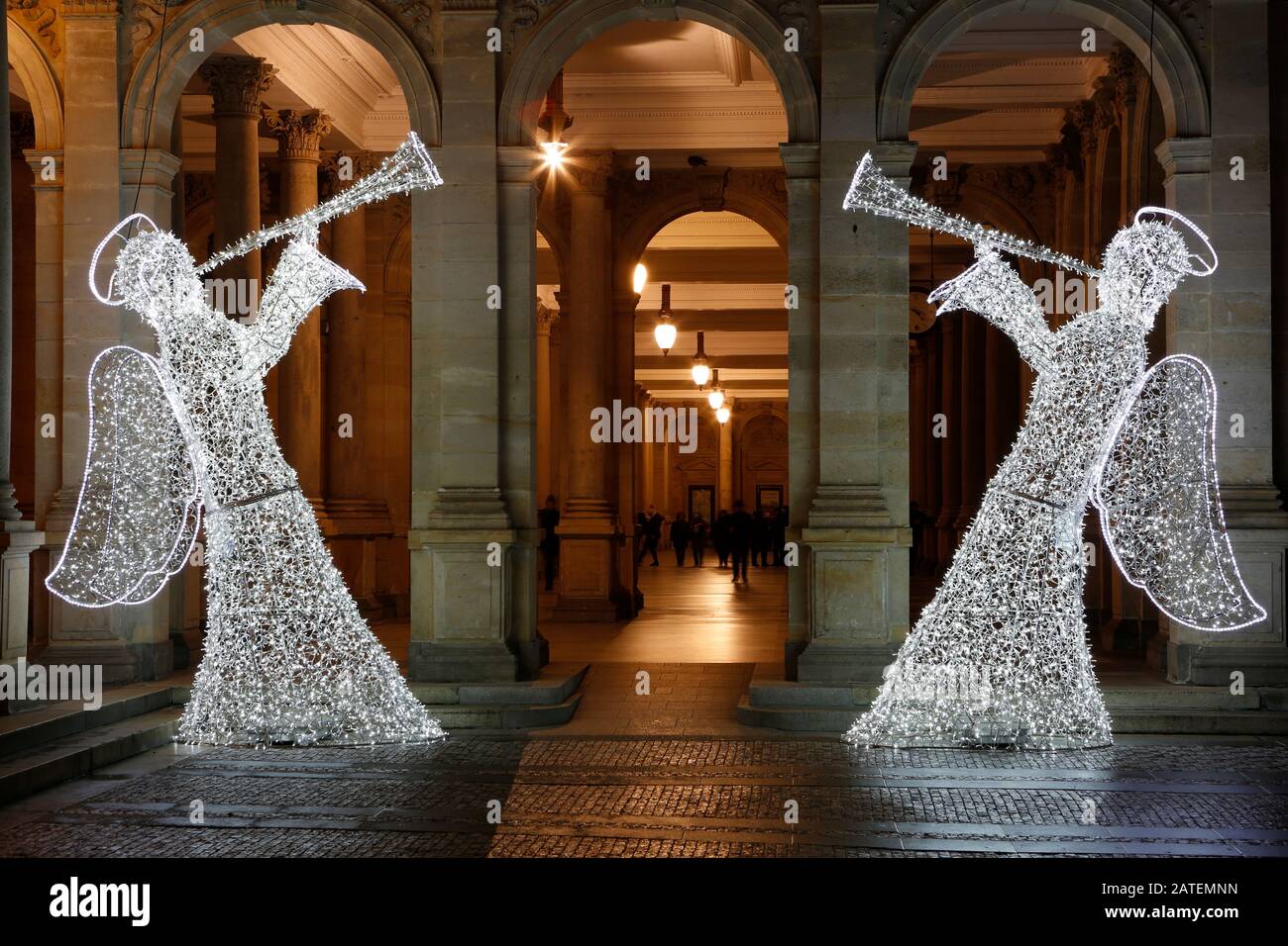 Due angeli leggeri come decorazioni in piedi di fronte al colonnato a Karlovy Vary a Natale Foto Stock