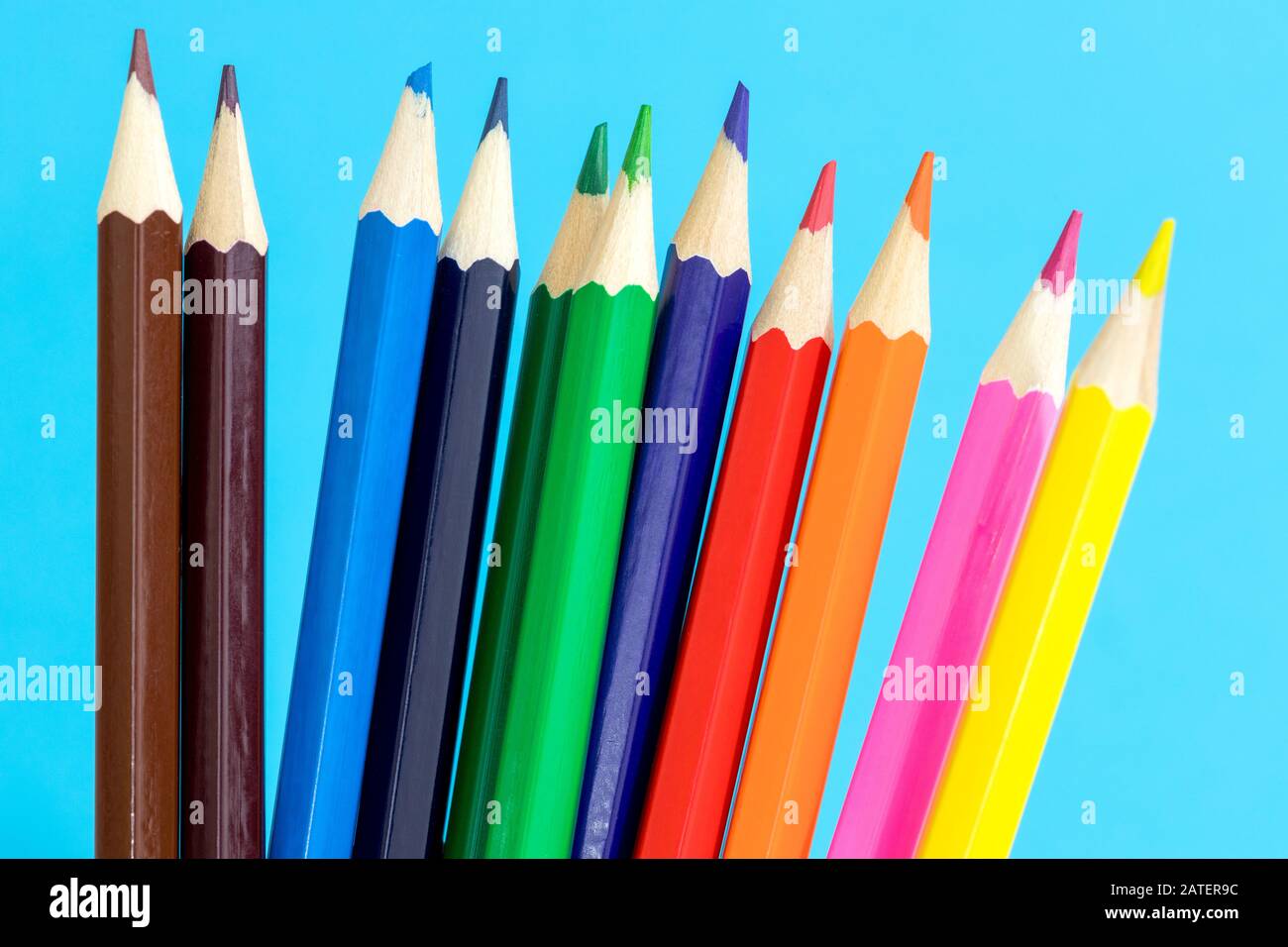 Matite multicolore su sfondo blu. Concetto scolastico Foto Stock