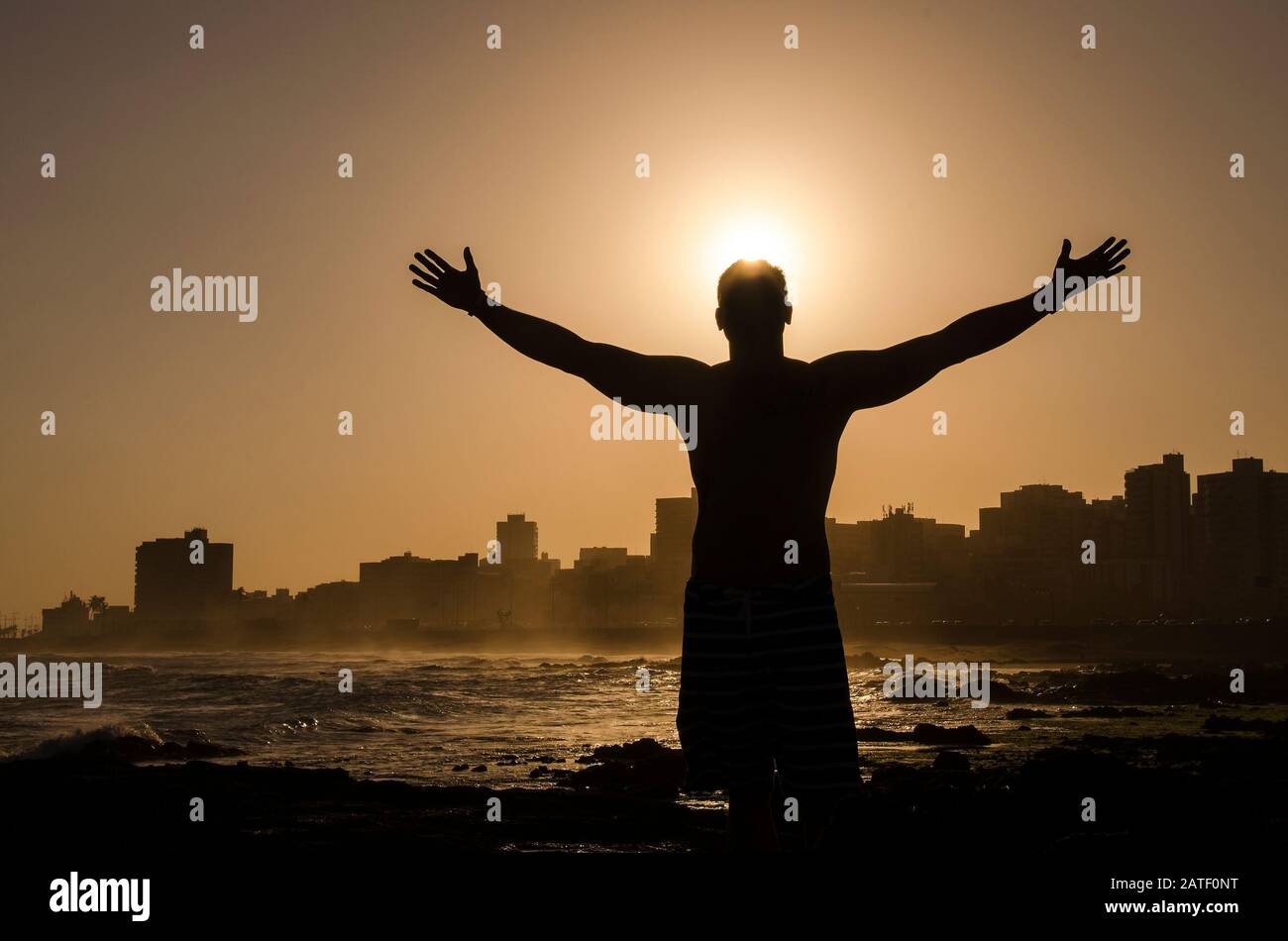 Silhouette di un uomo con le mani alzate nel concetto di tramonto per la religione, il culto e la preghiera e lode Foto Stock