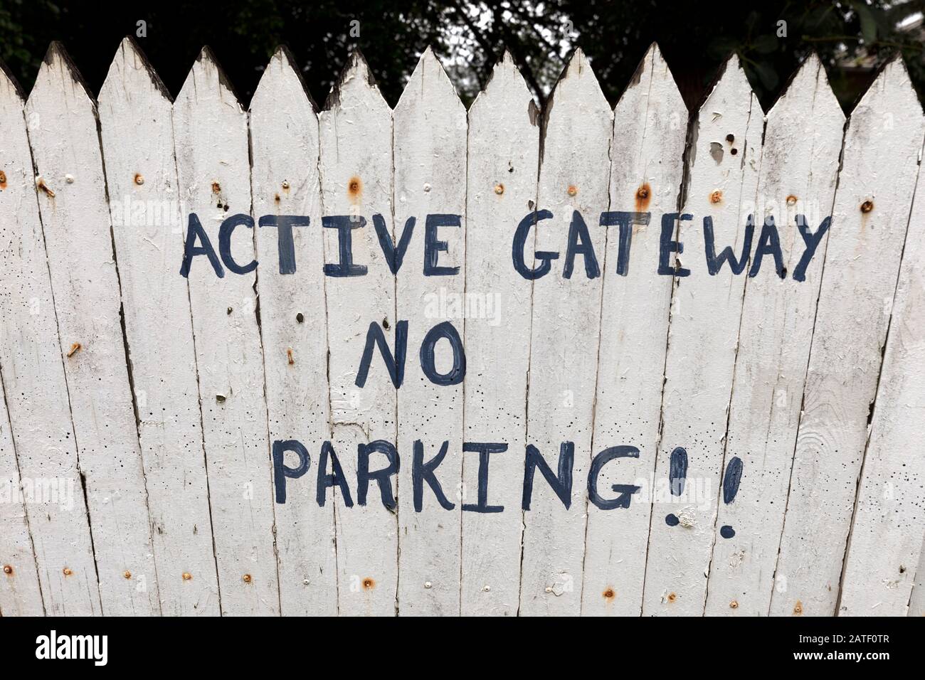 gateway attivo nessun parcheggio dipinto su una recinzione bianca in picchetto Foto Stock