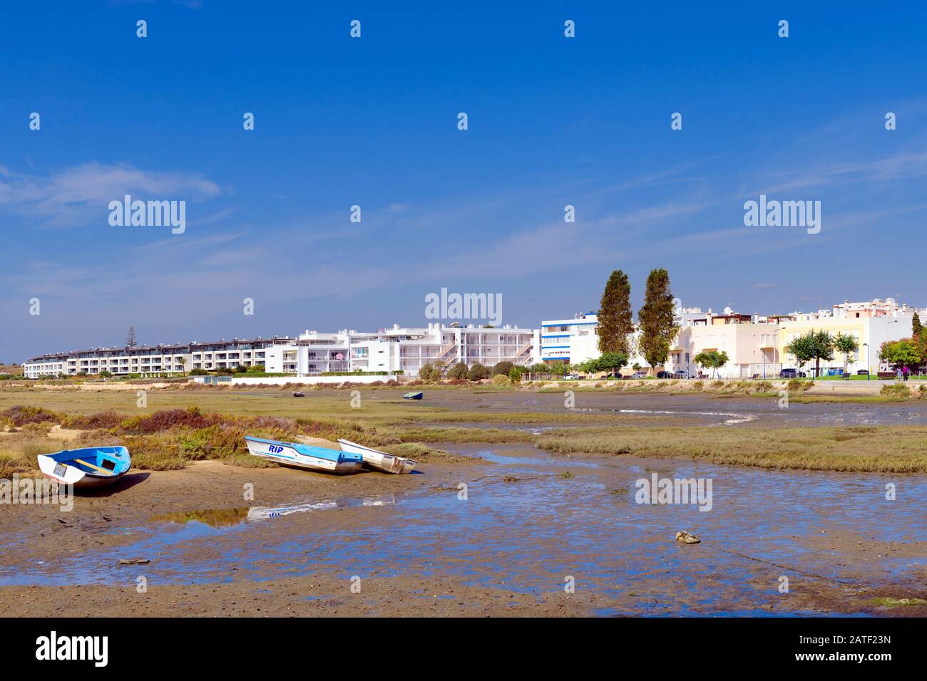 Barche sulla Ria Formosa con la città di Fuseta East Algarve sullo sfondo. Fuseta, Algarve, Portogallo. Foto Stock