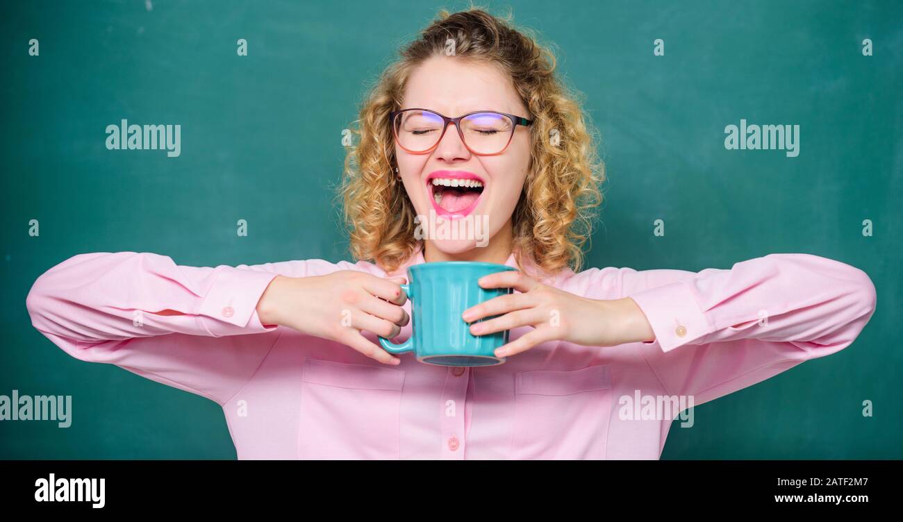Dipendenza dal caffè. Carica di energia per tutto il giorno. Dose di caffeina. Insegnante in bicchieri bere caffè chalkboard sfondo. L'insegnamento è il più grande atto di ottimismo. La donna ama il caffè prima delle lezioni scolastiche. Foto Stock