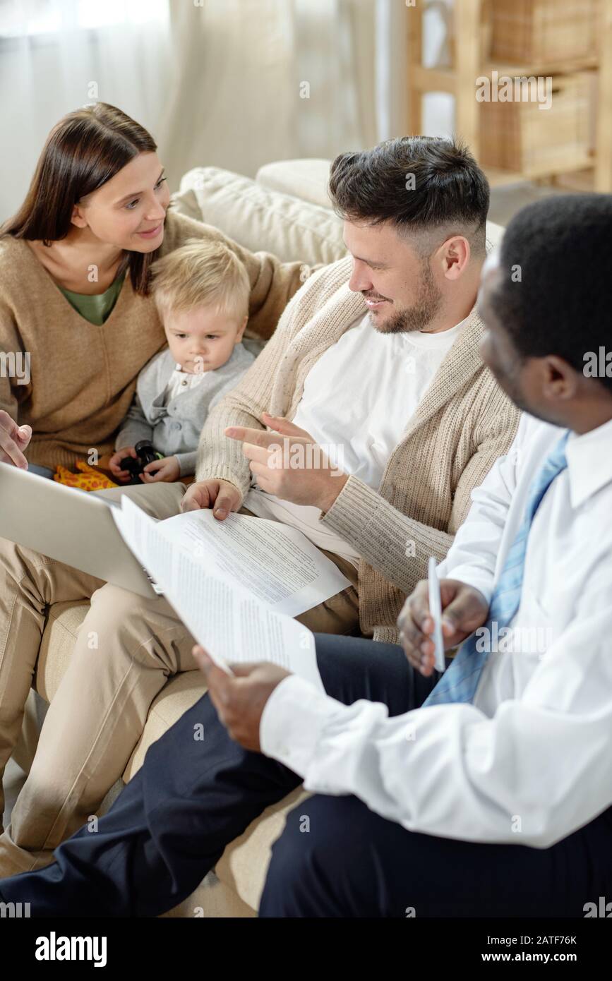 Famiglia allegra con l'uomo nero che discute il prestito domestico Foto Stock