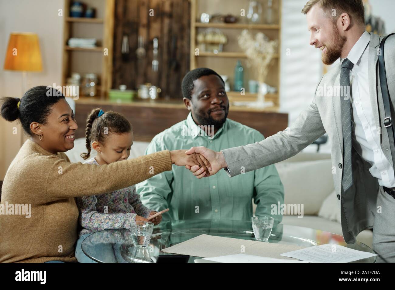 Incontro con la famiglia etnica con un consulente amichevole Foto Stock