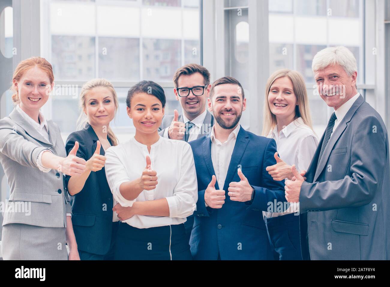 Ritratto di business team di persone che mostra Thumbs up , Ufficio personale in piedi nella lobby Foto Stock