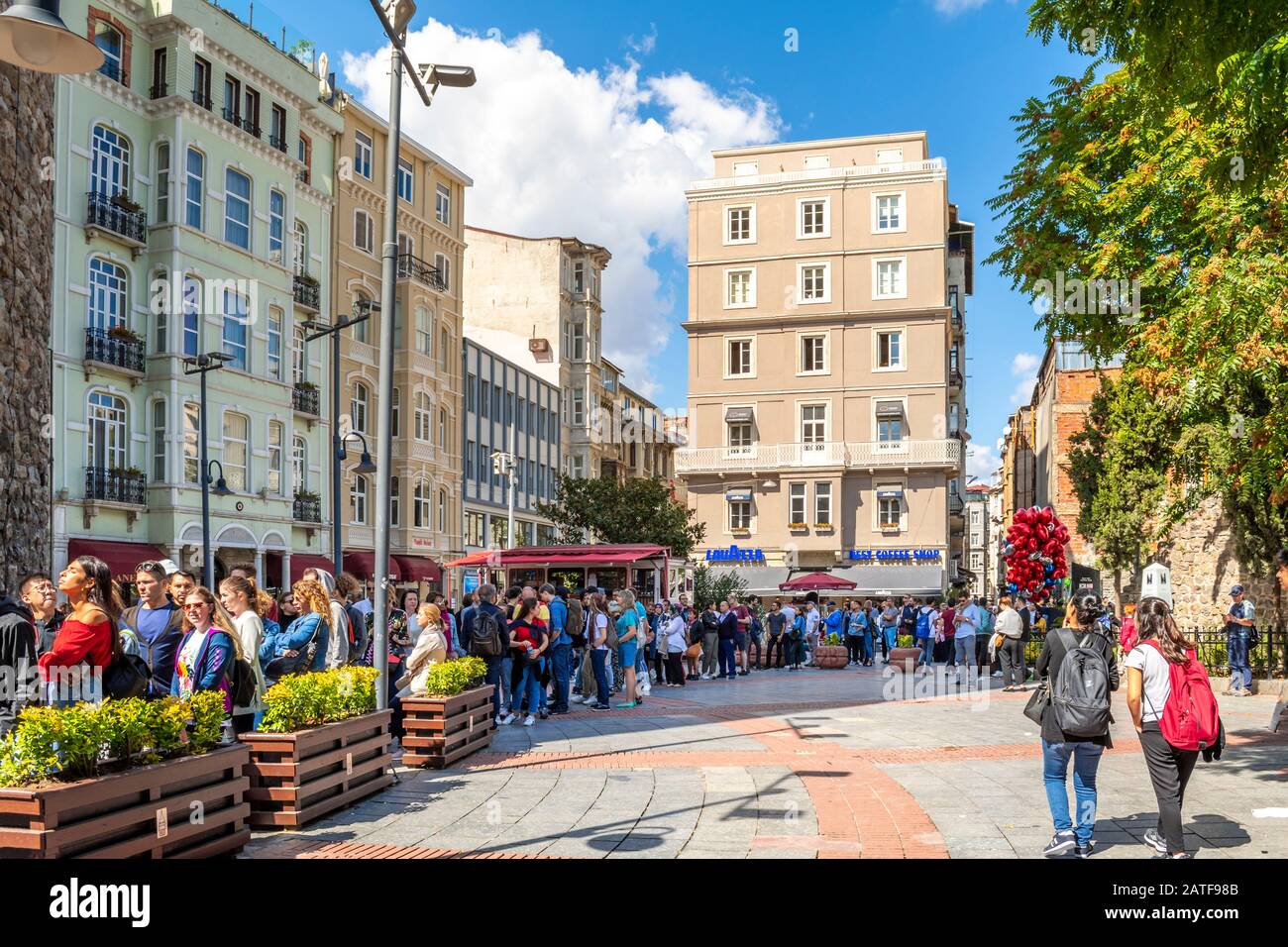 Viaggiatori e turisti attendono nella lunga linea per entrare nella Torre Galata nel quartiere Karakoy di Istanbul, Turchia. Foto Stock