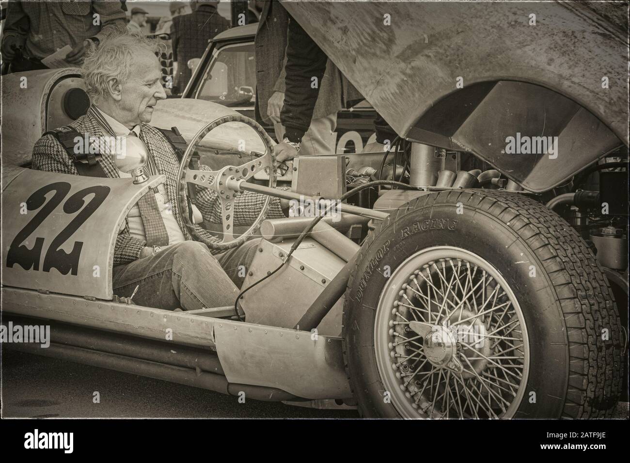 Un Signore siede in una vettura sportiva d'epoca con il cofano sollevato al Revival Goodwood Foto Stock